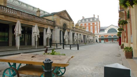 Lockdown-in-London,-deserted-Covent-Garden-Market-Piazza-with-2M-social-distancing-sign,-during-the-Coronavirus-pandemic-2020,-on-an-overcast-day