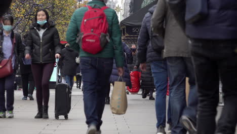 People-with-shopping-bags-walk-along-Oxford-Street-on-the-first-morning-the-new-Covid-regulation-three-tier-system-is-implemented-that-allows-non-essential-businesses-to-open-prior-to-Christmas