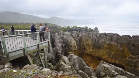 Tourists-on-a-viewing-platform-taking-photos-of-a-blowhole