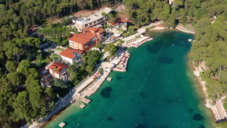 Aerial-view-of-crystal-clear-water-small-bay-next-to-hotel-and-sea-deck