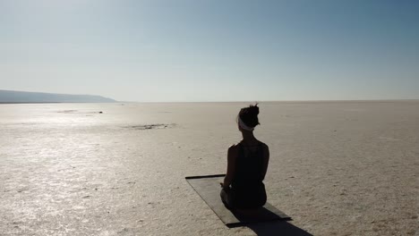 Woman-teacher-doing-meditation-pose-on-the-Lake-Tuz,-Salar-in-Turkey