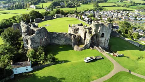 Ancient-British-landmark-Denbigh-Castle-medieval-old-hill-monument-ruin-tourist-attraction-aerial-rising-forward-view
