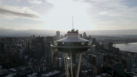 Sunshine-reflects-off-the-glass-observation-deck-of-the-iconic-Seattle-Space-Needle,-aerial-orbit