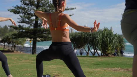 Chicas-En-Ropa-Deportiva-Practicando-Yoga-Haciendo-ángulo-Lateral-Extendido---Burleigh-Hill-Y-Burleigh-Heads-Beach---Gold-Coast,-Qld,-Australia