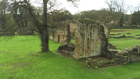 Basingwerk-abbey-landmark-medieval-abandoned-Welsh-ruins-Aerial-view-low-left-fly-past