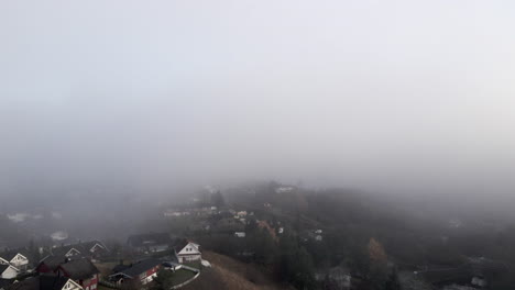 A-neighbourhood-in-a-foggy-day,-filmed-from-the-sky