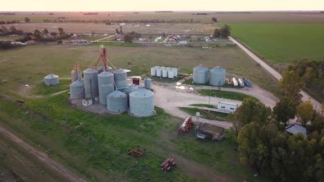 Aerial-shot-of-old-agricultural-silos-at-sunset-in-a-small-rural-town