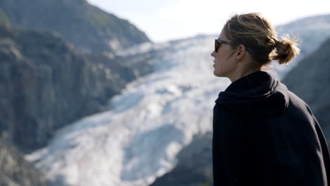 Female-Standing-in-Front-of-Alaskan-Glacier,-Slow-Motion-Changing-Depth-of-Focus-Shot