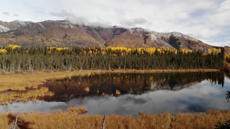 Herbstfarben-Des-Borealen-Waldes-Spiegeln-Sich-In-Einem-Stillen-See-Unter-Einer-Wolkenlandschaft-In-Alaska,-Usa-Wider