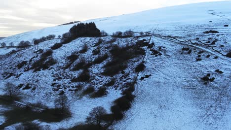Moel-Famau-Welsh-snowy-mountain-valley-aerial-view-cold-agricultural-rural-winter-landscape-slow-rising
