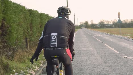 Slow-motion-lone-cyclist-pointing-at-hazard-while-road-cycling