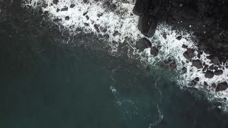 Riesige-Meereswellen,-Die-Auf-Die-Grauen-Felsen-Unterhalb-Einer-Felsenklippe-Auf-Der-Isle-Of-Skye-Ocean-Schottland-Schlagen