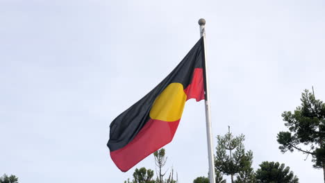 Aborigine-Flagge-In-Zeitlupe,-Die-Am-Abendhimmel-Weht