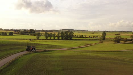 Tractor-driving-through-fields-in-southern-Sweden
