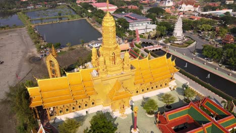 4k-Aerial-of-Beautiful-golden-temple-with-the-golden-standing-buddha-statue-in-the-Ancient-City-park,-Muang-Boran,-Samut-Prakan-province