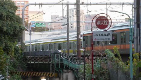 Zwei-U-Bahn-Züge,-Die-Tagsüber-Am-Bahnhof-In-Tokio,-Japan,-Vorbeifahren