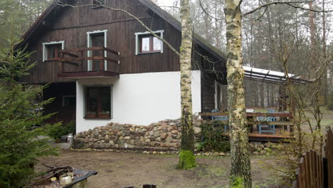 Schöne-Holzhütte,-Umgeben-Von-Bäumen-An-Einem-Nebligen-Morgen-In-Bartoszylas,-Polen