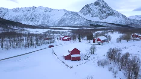 Auto-Unterwegs-Auf-Der-Landstraße-In-Der-Nähe-Eines-Friedlichen-Dorfes-Mit-Bergketten-Im-Hintergrund-Im-Winter-Auf-Der-Insel-Andoya,-Norwegen