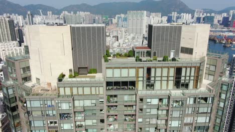 Toma-Aérea-De-Mega-Rascacielos-Residenciales-Y-Tráfico-En-El-Centro-De-Hong-Kong,-En-Un-Hermoso-Día