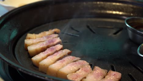 Smoke-Coming-out-From-Charcoal-Griller-With-Korean-Pork-Belly---Samgyeopsal-In-Korean-Restaurant