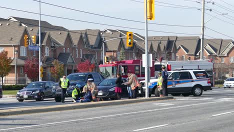 Police-and-firefighters-at-scene-of-pedestrian-accident,-consoling-black-man-sitting-on-the-road