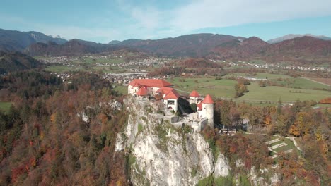 The-castle-situated-on-a-rock-in-the-alpine-region-of-Slovenia-with-the-Alps-in-the-background-with-a-stunning-aerial-view-of-the-grad