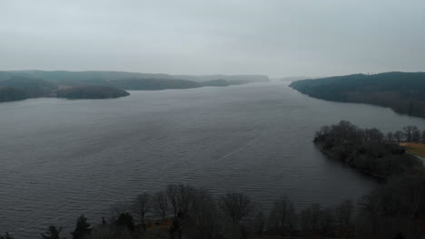 Drone-Pedestal-Shot-of-Grey-Lake-Landscape-on-a-Gloomy,-Overcast-Day