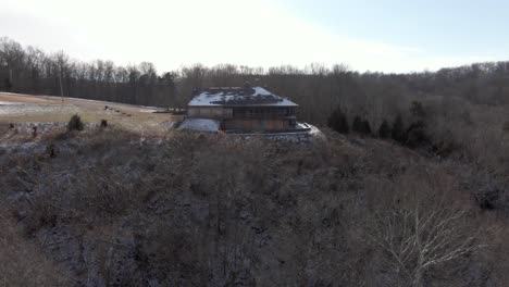 Luftaufnahmen-Von-Drohnen,-Die-Im-Winter-Zu-Einer-Verlassenen-Hütte-Auf-Einem-Hügel-Fahren