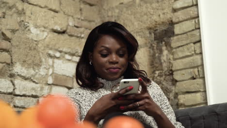 American-black-woman-smiling-texting-on-a-cellphone