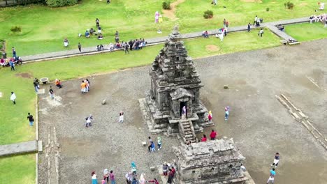 People-visiting-small-Hindu-Arjuna-temple-of-Dieng-sanctuary-cluster,-Indonesia