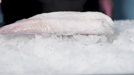 Frozen-Fish-Meat-Falls-Into-Crushed-Ice-Bed-On-Public-Market