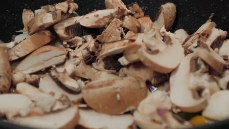 Motion-controlled-slow-motion-shot-of-mushrooms-in-a-cooking-pan