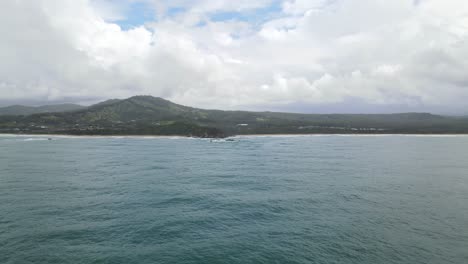Beautiful-Seascape-With-Blue-Cloudy-Sky-And-Mountains-In-Background-In-Sapphire-Beach,-Coffs-Harbour,-NSW,-Australia---aerial-drone-shot