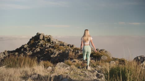 Fit-blond-woman-hiking-above-clouds-on-scenic-mountains-in-Madeira