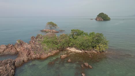 Aerial-birds-eye-view-drone-fly-over-shot-of-a-small-deserted-tropical-island-in-South-east-Asia