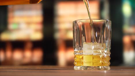 Whiskey-Wird-Mit-Eis-In-Ein-Glas-Gegossen-4k