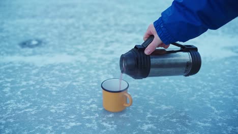 Person,-Die-Während-Des-Eiskalten-Wintermorgens-In-Norwegen-Heißen-Tee-In-Eine-Tasse-Gießt