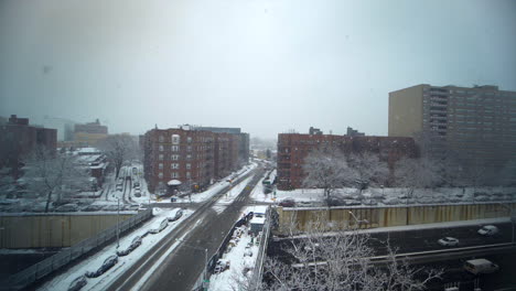 slow-motion-pan-across-cityscape-in-Brooklyn,-New-York-City,-NY-as-snow-falls-heavily-on-the-expressway
