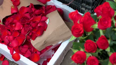 Rote-Rosenblätter-Sind-Im-Boden-Zu-Sehen,-Während-Eine-Rosenboutique-Während-Des-Valentinstags-Auf-Einem-Blumenmarkt-Zum-Verkauf-Angeboten-Wird