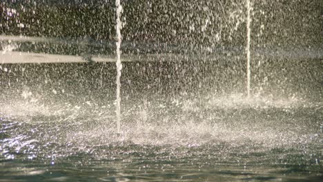 Closeup-of-water-drops-spreading-around-fountains,-abstract-texture-with-slow-motion