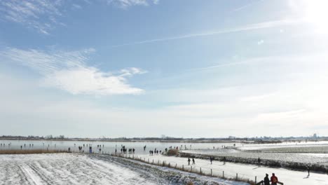 People-ice-skating-on-a-frozen-lake-on-a-sunny-winter-day-in-the-Netherlands-during-the-pandemic