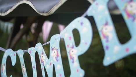 Blue-happy-bithday-letters-with-unicorns-hanging-in-a-garden-party-event