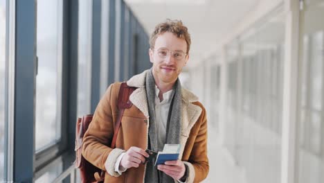 Cute-young-man-shows-documents-with-a-ticket-and-a-plastic-card