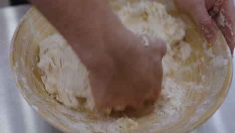 Kneading-the-pizza-dough-inside-big-wooden-bamboo-bowl