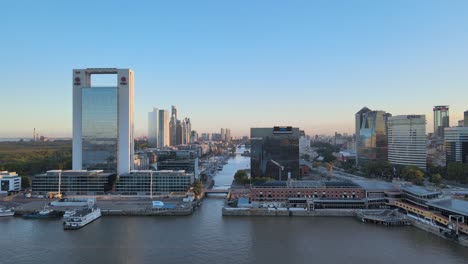 Aerial-dolly-in-from-north-dock-of-Puerto-Madero-toward-the-waterfront-high-rise-buildings-and-straight-downtown-waterway-at-the-central-business-district-of-Buenos-Aires