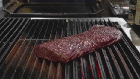 Chef-puts-big-venison-meat-slice-onto-a-grill