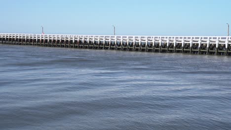 Wide-shot-of-tranquil-water-palisade-on-canal-Nieuwpoort-during-sunny-day-with-blue-sky-in-Belgium
