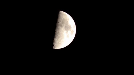 Nightime-closeup-of-quarter-moon-descending-against-a-black-sky