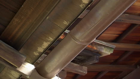 Drops-of-water-drip-into-copper-roof-gutter
