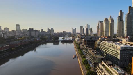 Backing-aerial-shot-of-river-through-Puerto-Madero-in-Buenos-Aires